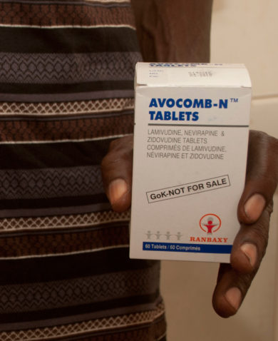 Image of a man holding a box of Avocomb-N tablets in one hand and pills in the other.