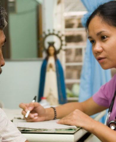 A healthcare worker interviewing a patient and taking notes.