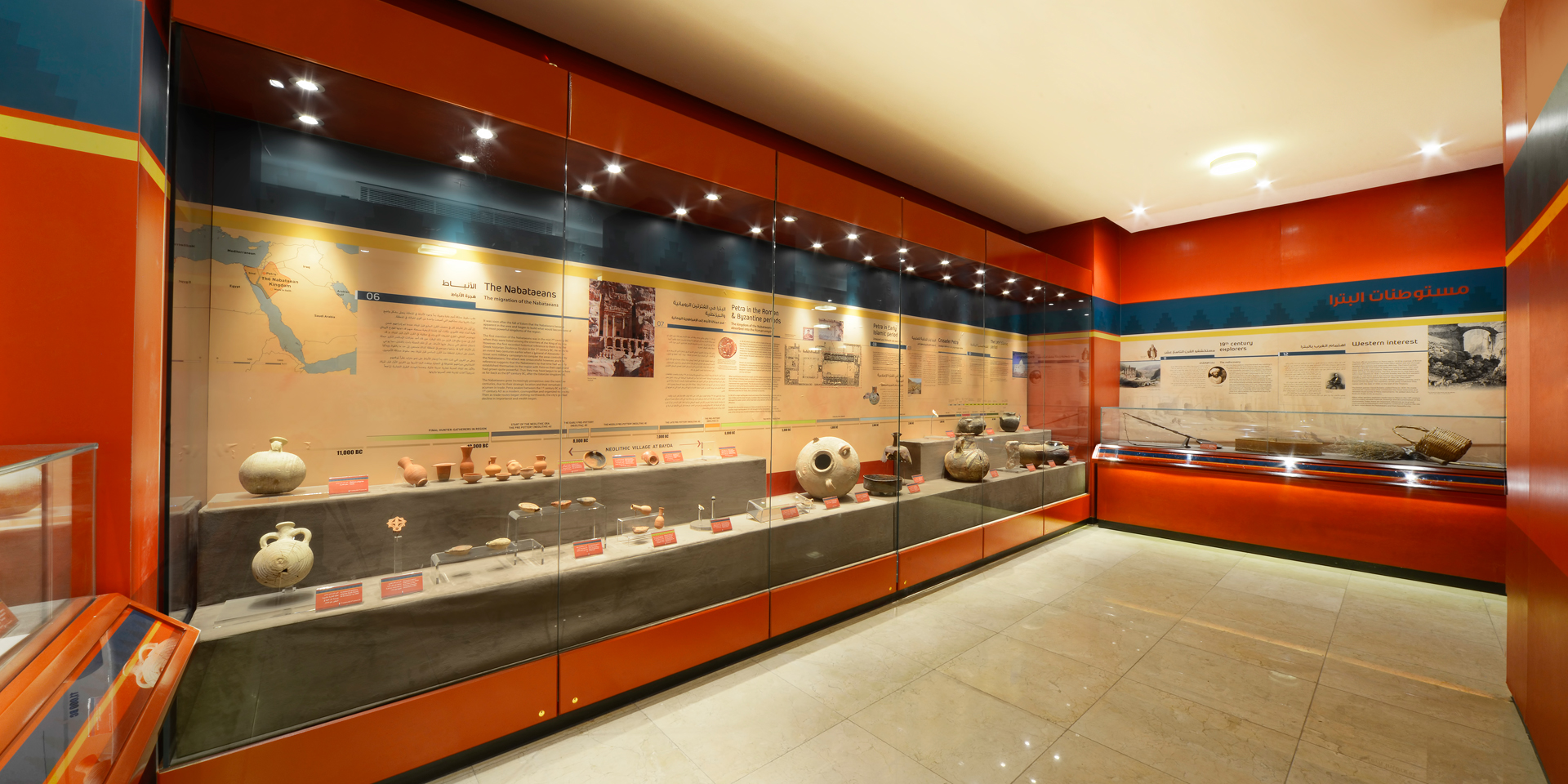 A museum exhibit with several examples f ancient pottery protected behind glass.