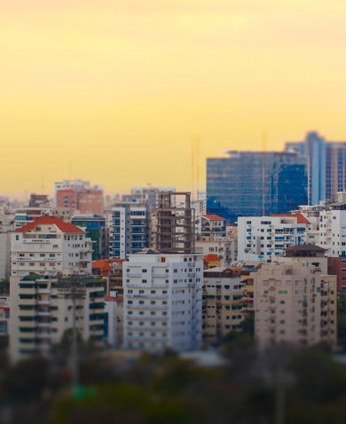 A city skyline with several colorful buildings dotting the landscape.