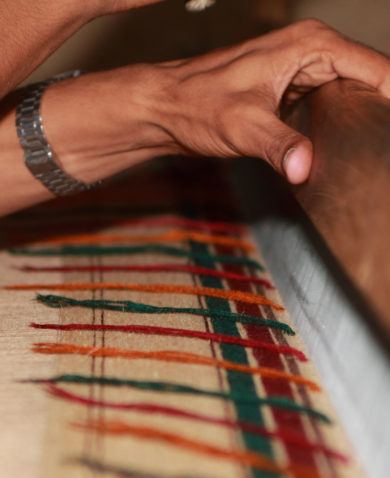 A close-up of hands operating a loom.
