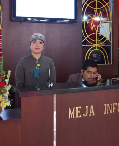Image of two people operating a receptionist desk.