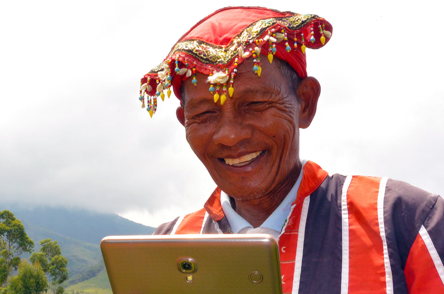 Image of a man smiling while operating a tablet.