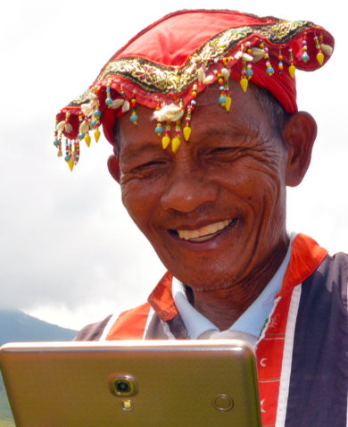 Image of a man smiling while operating a tablet.