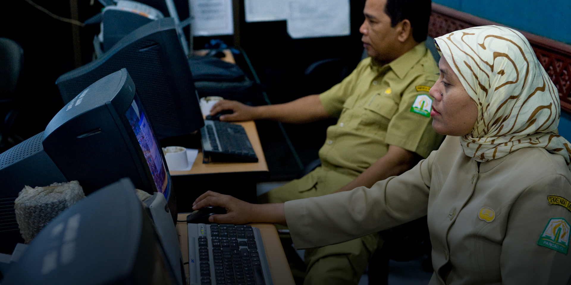 A pair of security personnel working on computers.