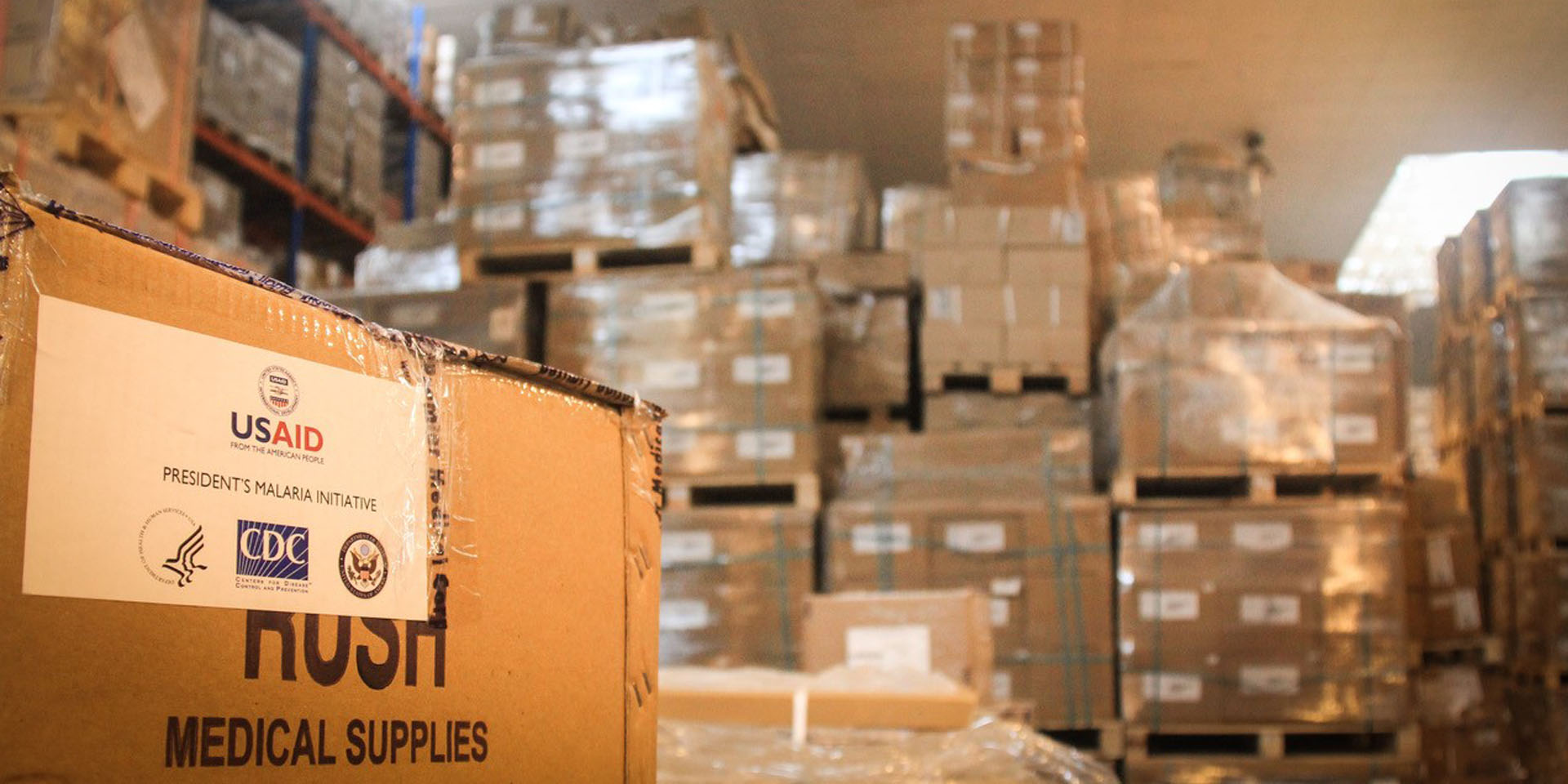 A warehouse filled with pallets of cardboard boxes marked with the text 