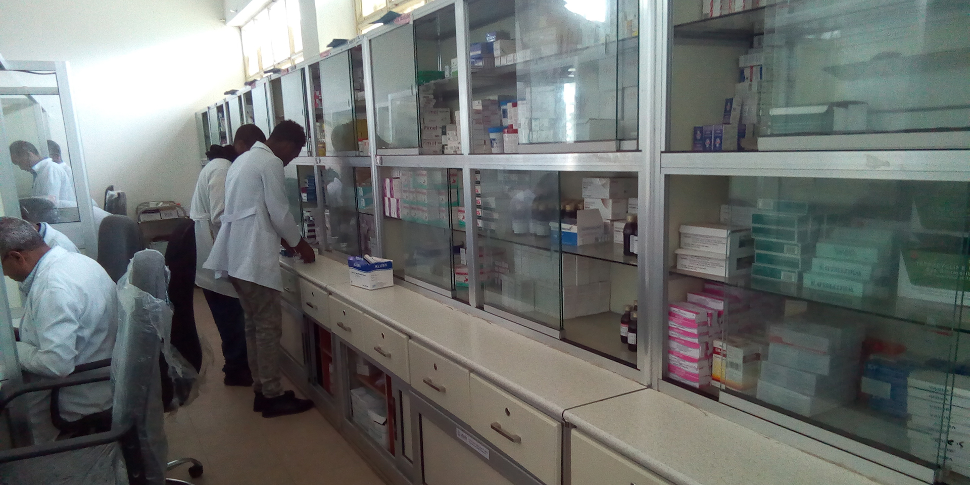 Image of a pharmacy with technicians filling prescriptions.
