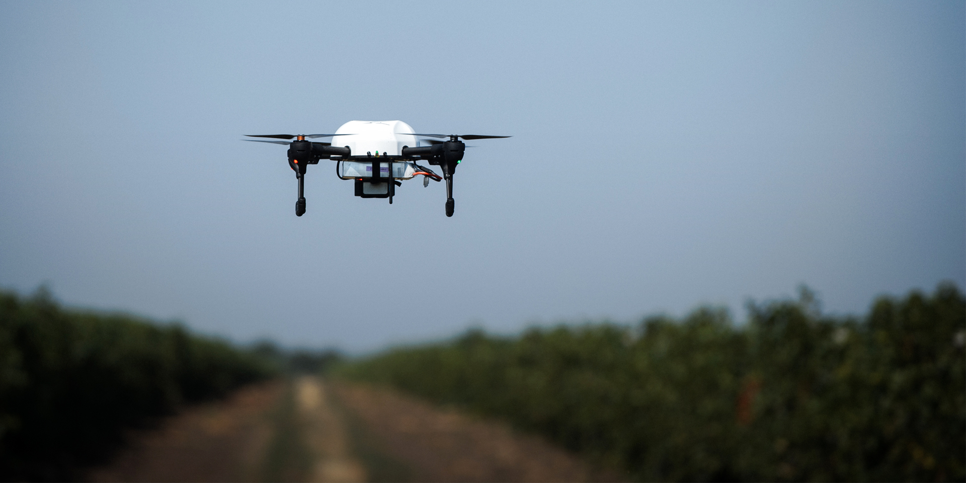 Image of a drone flying over farmland.