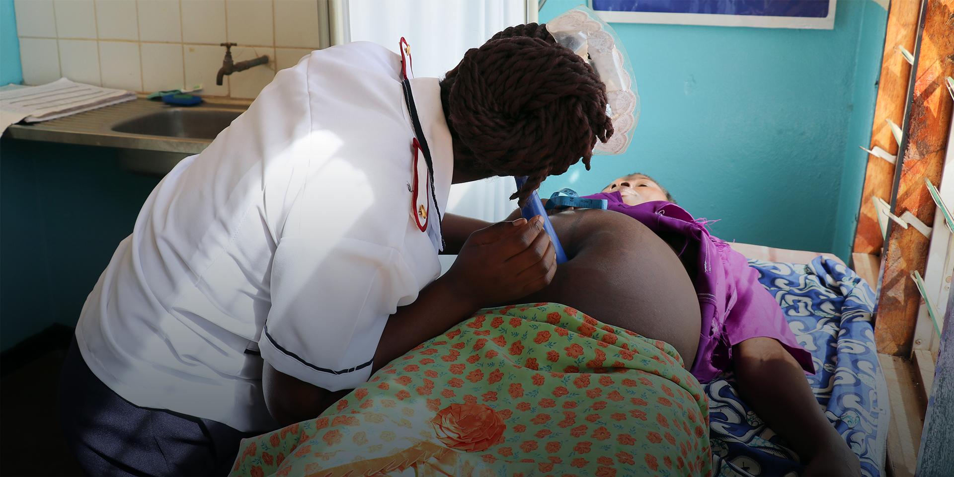 Image of a healthcare worker examining a pregnant woman.