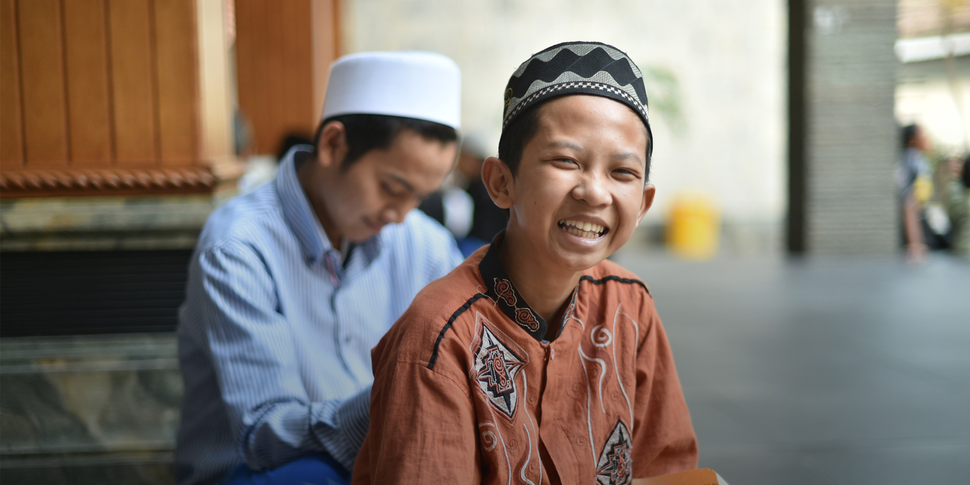 Indonesian child smiling with a book in his lap