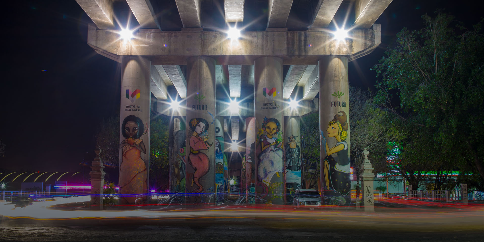 Image of four bridge columns each with a mural showing women from different cultural backgrounds.