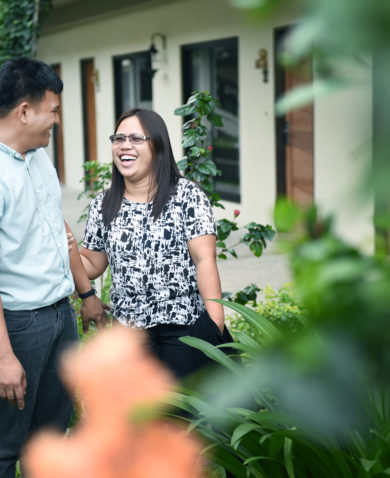 Image of a couple laughing in a yard.