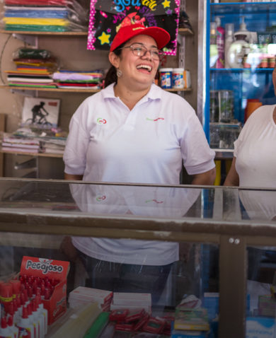 Four women socialize around a store counter in Colombia