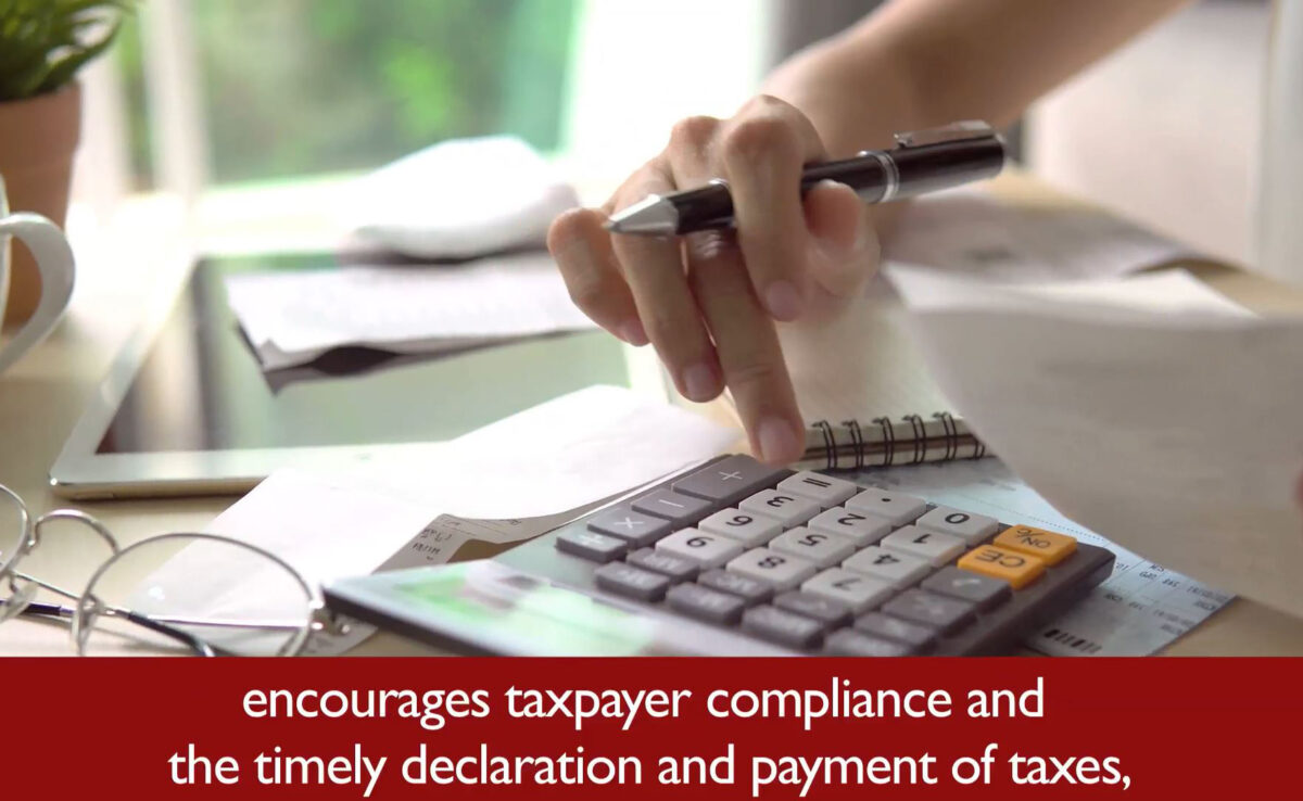 A close-up image of a hand operating a calculator. Below the image is a closed caption that reads "encourages taxpayer compliance and the timely declaration and payment of taxes."