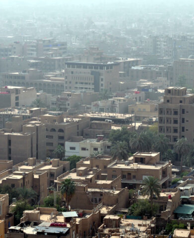 This skyline of downtown Baghdad including several tall brown buildings.