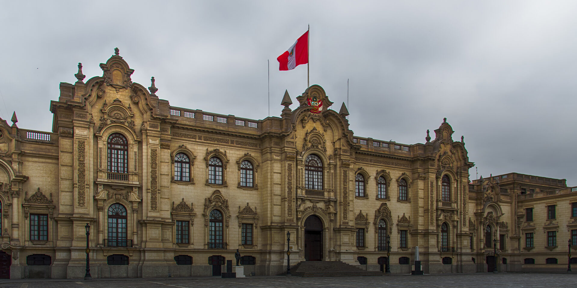 An elegant building with the Peruvian Flag waving from the rooftop.