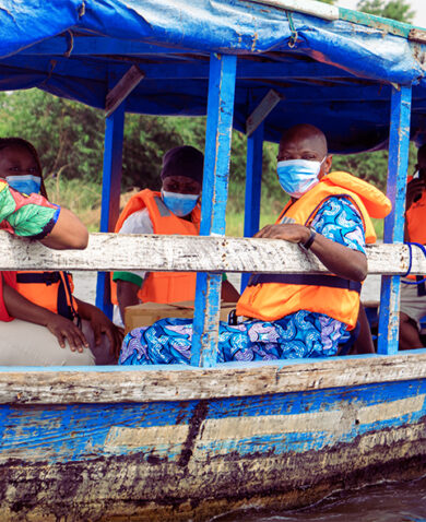Several people riding in a blue wooden boat.