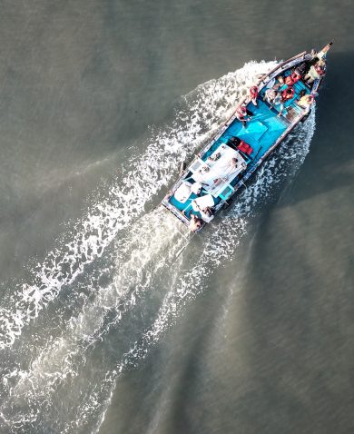 An overhead photo of a boat going across the ocean.