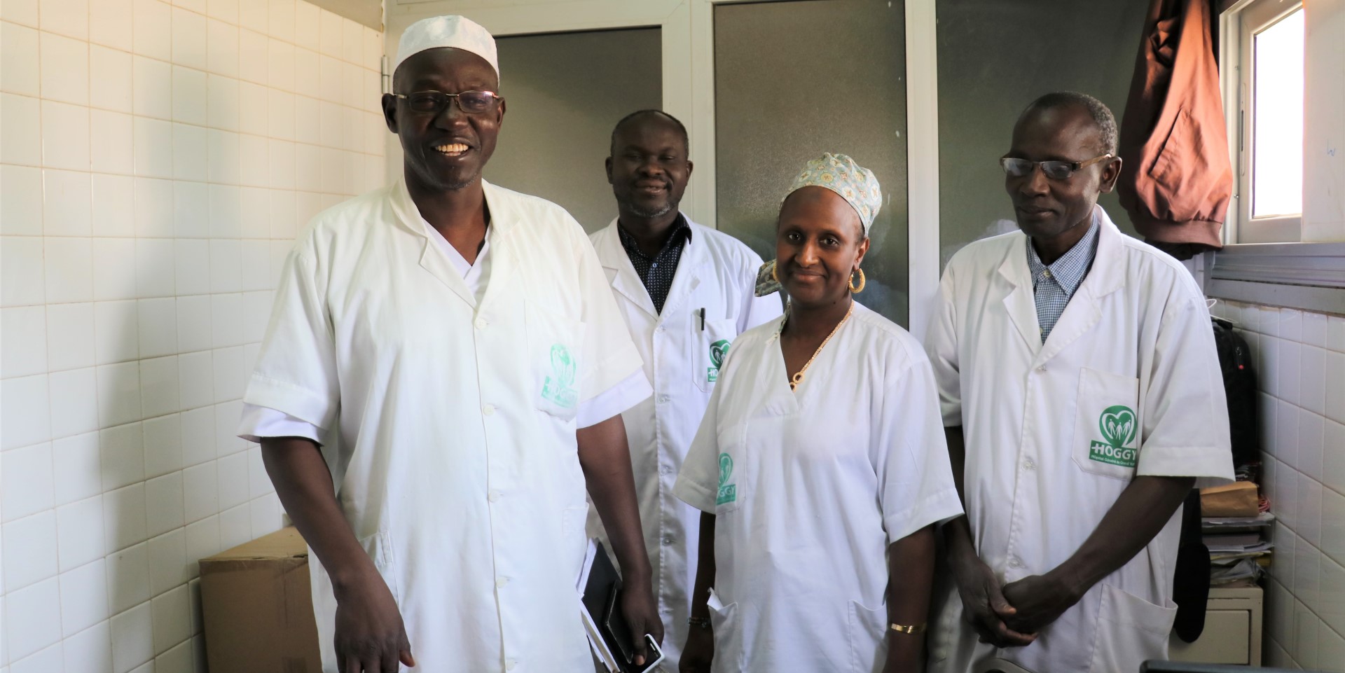 Four healthcare workers smiling and posing for a photo.
