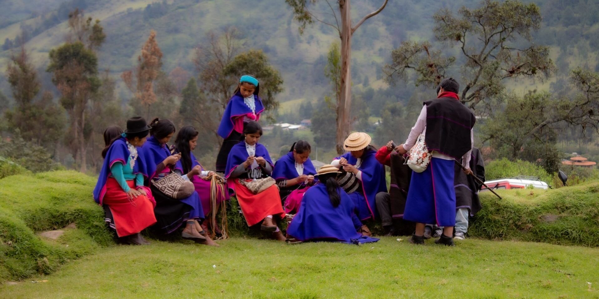 Group of women work on crafts in a field in Colombia
