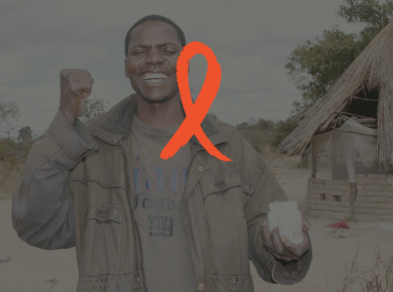 Image of man with a World AIDS Day ribbon in front of him