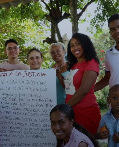 Group of people post with an oversized "letter to justice" written in Spanish