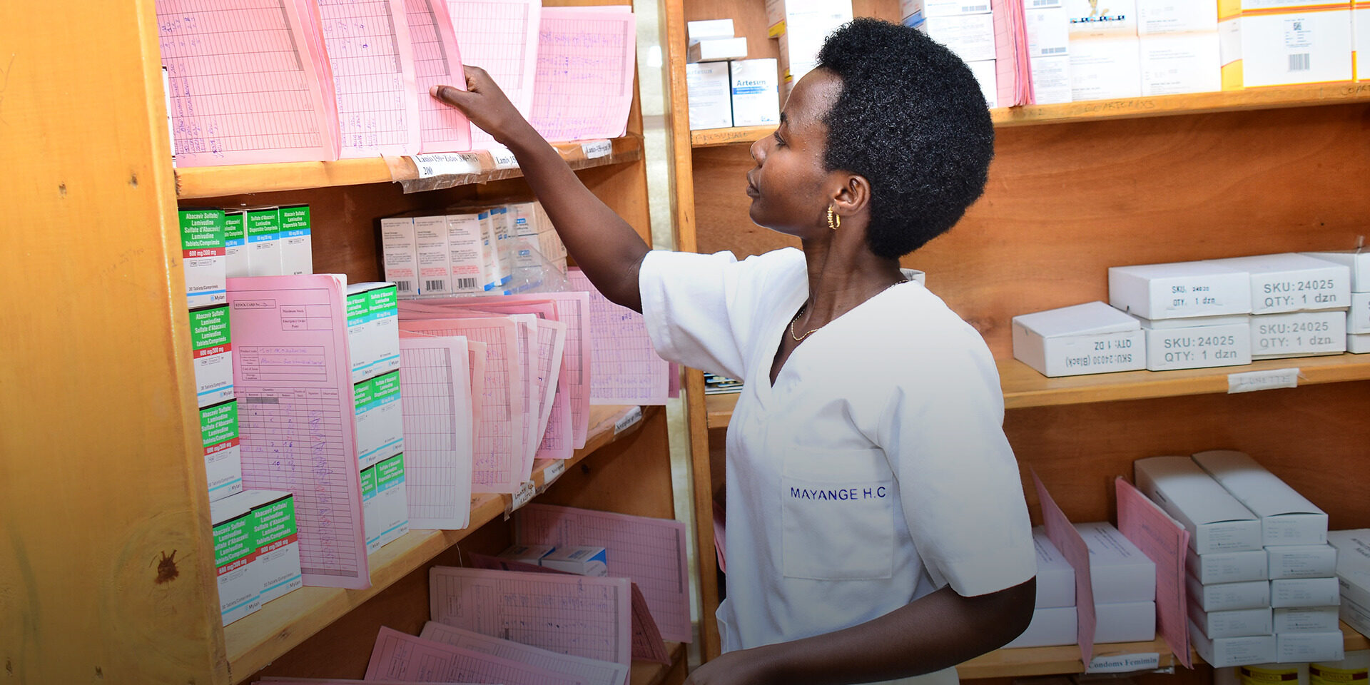 a female pharmacist stocks folders in a shelf