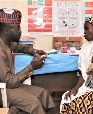 health worker talking to a mother in a malaria-related health visit