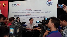 A man is interviewed by the media in front of a USAID backdrop