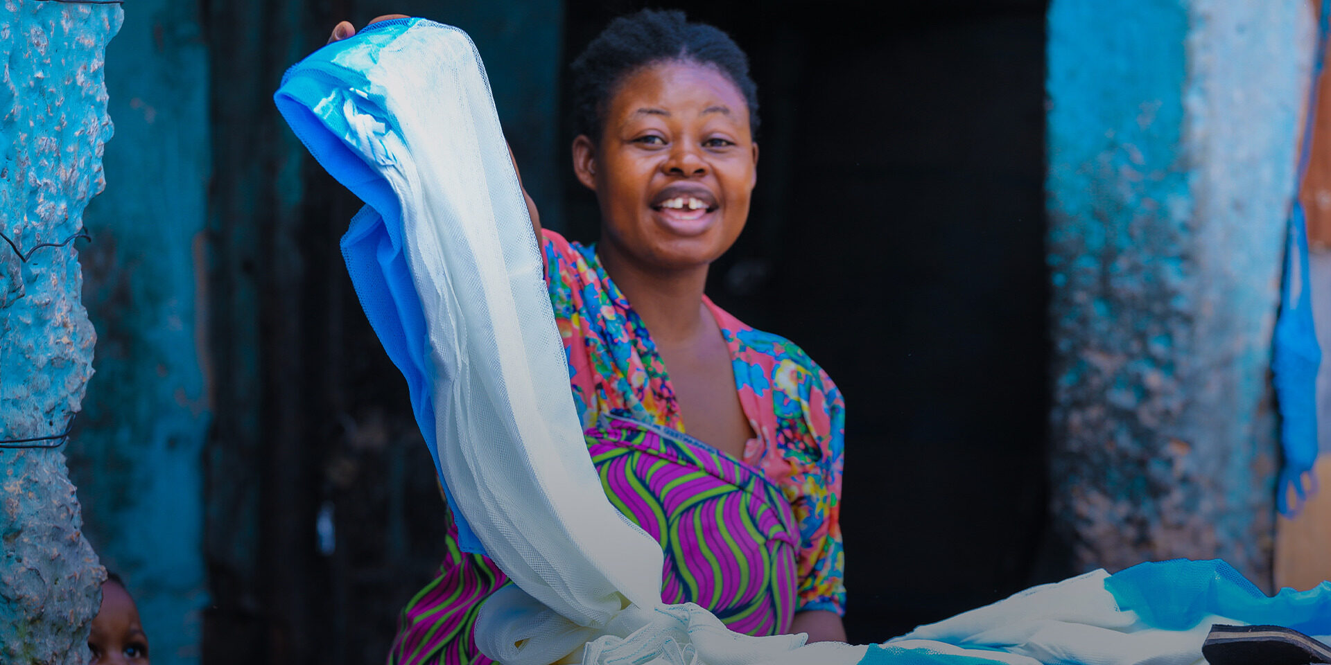 A woman shows a new bednet delivered in a recent mass campaign.