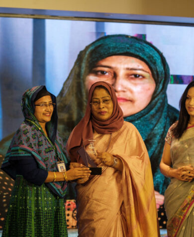 A woman receives an award at the Women Rise event in Bangladesh.