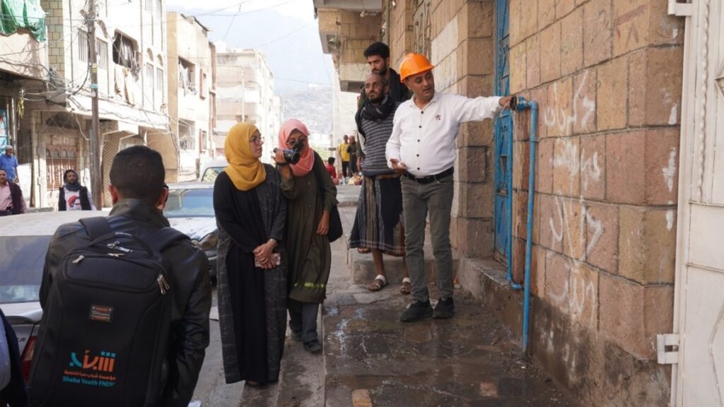 People gathered around a water pump in Yemen