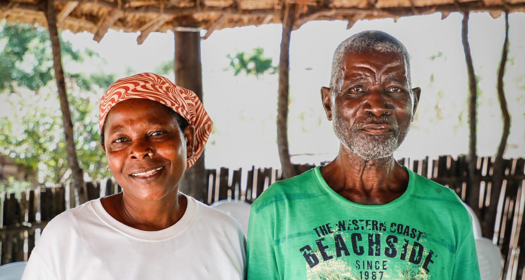 A health worker stands alongside a community member in Mozambique.