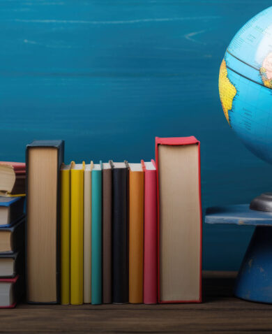 Stacks of books next to a globe.