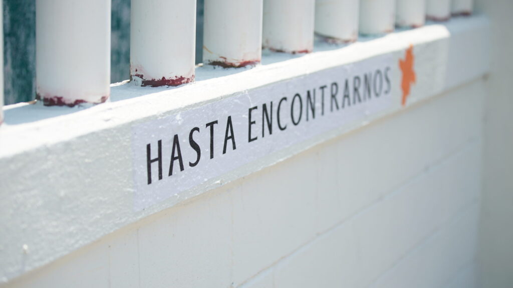"Hasta Encontrarnos" is written in black on a white wall