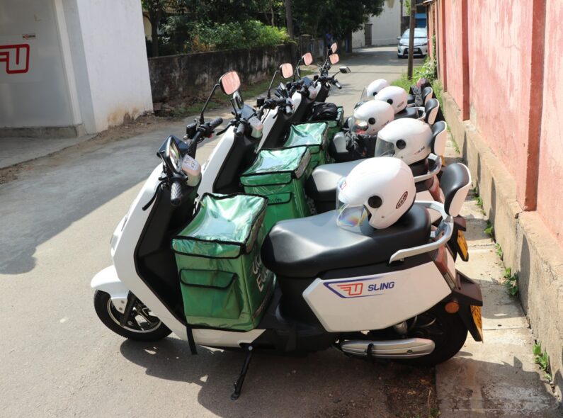 A row of electric 2-wheelers with white helmets