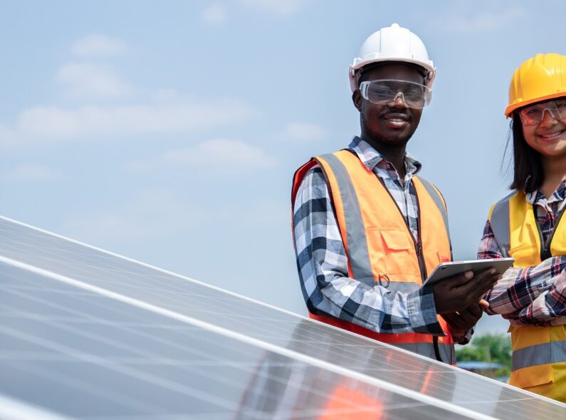 Two young people oversee the installation of solar panels
