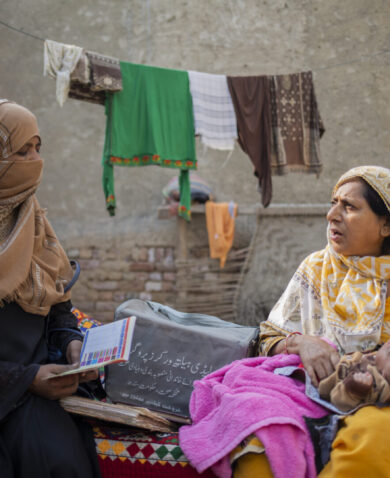 A lady health worker in patient consultation with a new mother.