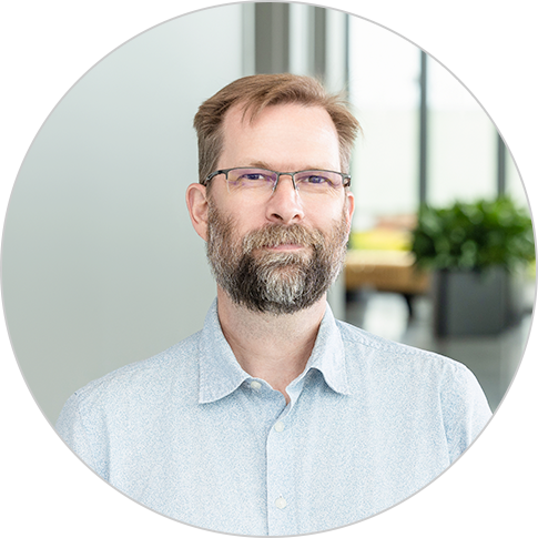 Picture of a man with a salt and pepper beard man wearing a button down