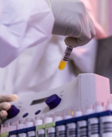 A lab worker examines specimens in test tubes.