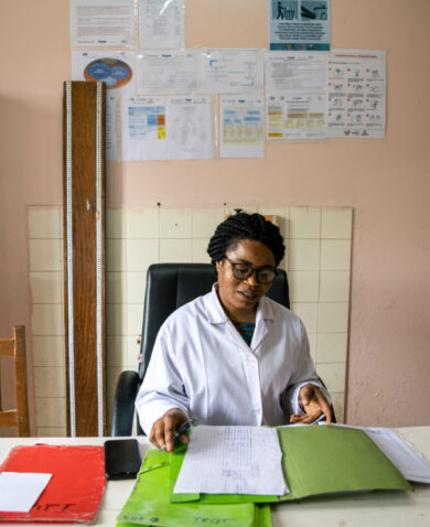 A health worker reviews some documents in a hospital room.