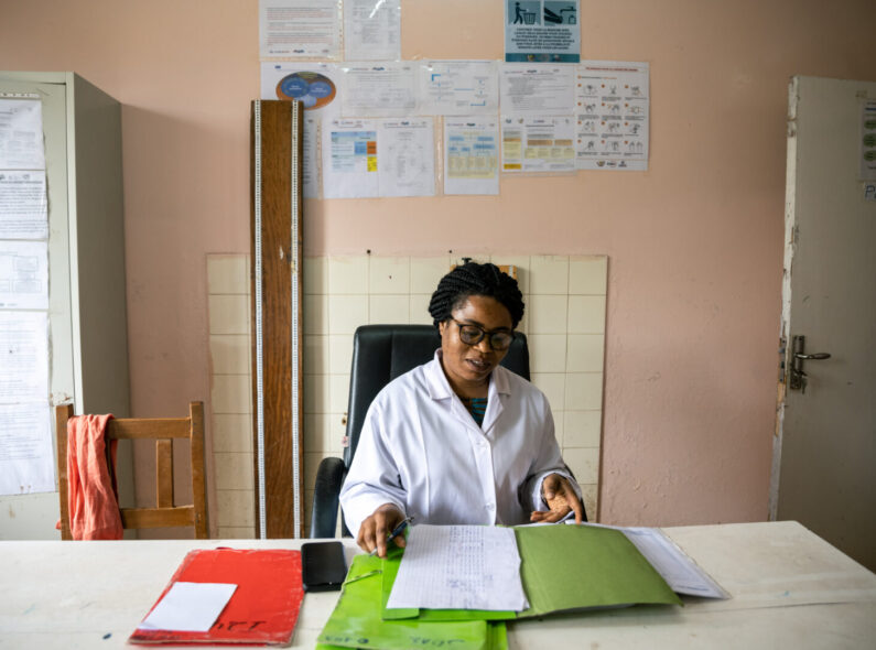 A health worker reviews some documents in a hospital room.