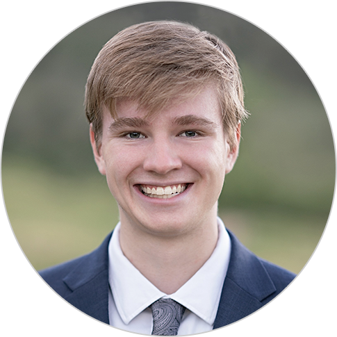 A headshot of a blond man smiling.