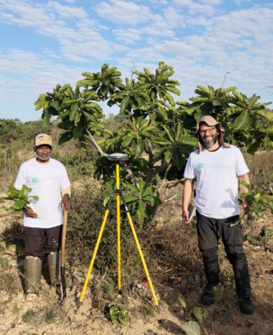 A forest steward and biologist stand in front of trees in Brazil