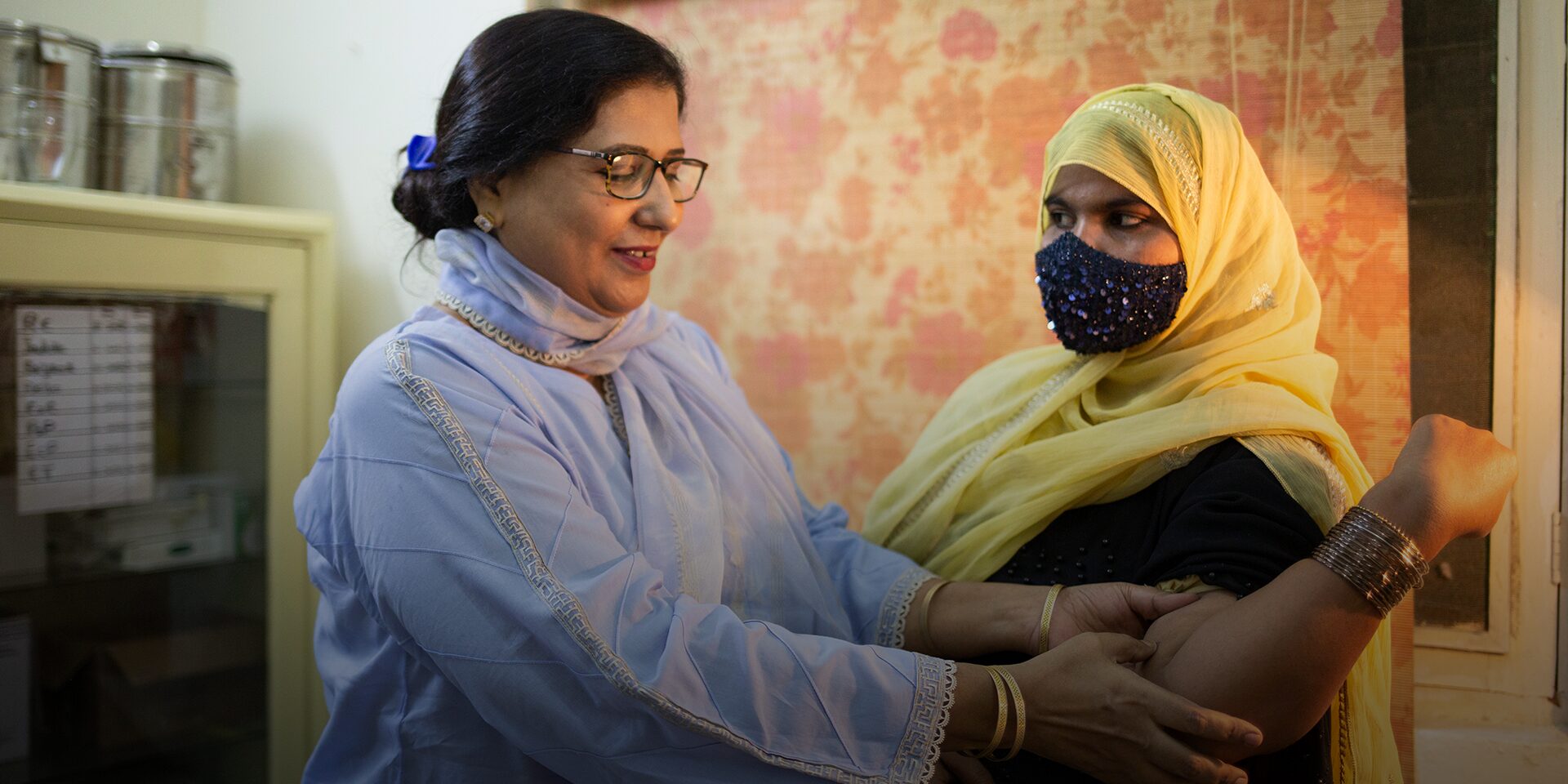 A doctor looks at a patient who has an implant for contraception at a health center.