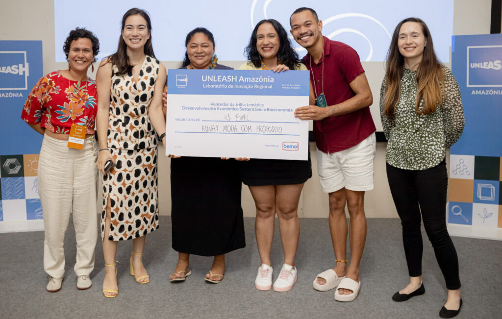 Ashley Valle, Latin America and Caribbean Program Director, presenting a check to one of the winning teams