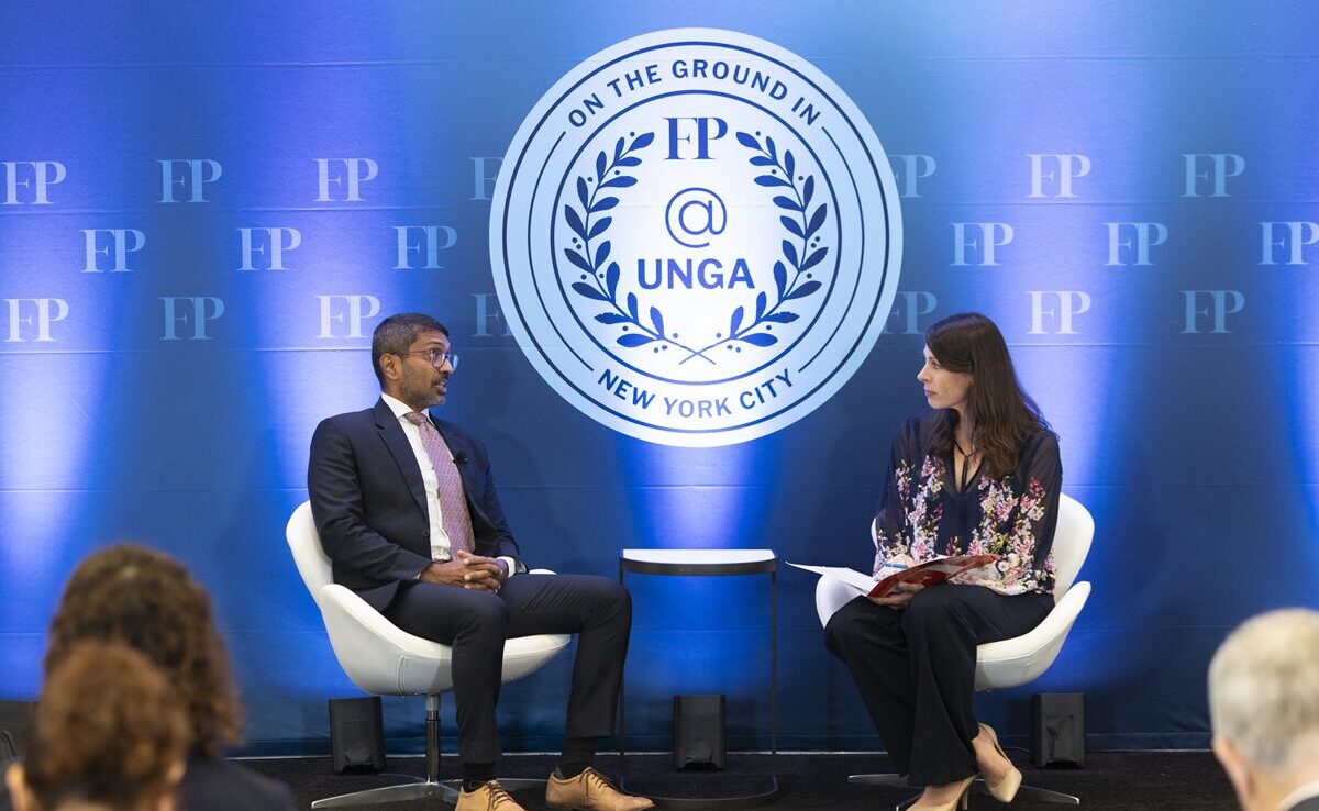 Two people facing each other in conversation, seated on a stage, as seen from the audience